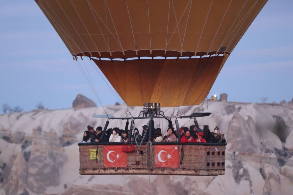 A group of people enjoying a hot air balloon ride over the unique landscapes of Cappadocia.