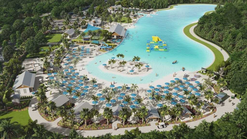 South Shore Bay Lagoon as viewed from sky with crystal blue water and sun loungers alongside water slides and inflatable water park rides.